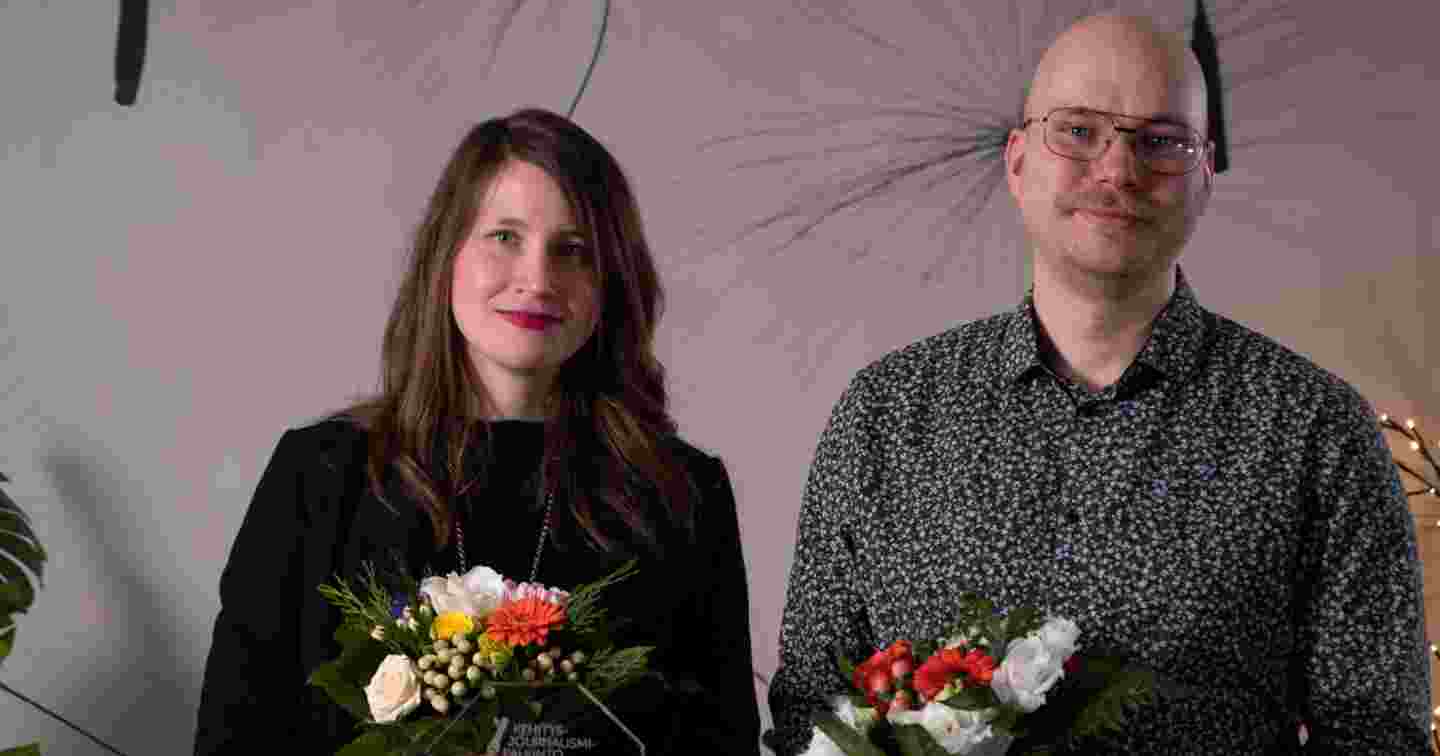 En man och en kvinna med blommorna i händerna.