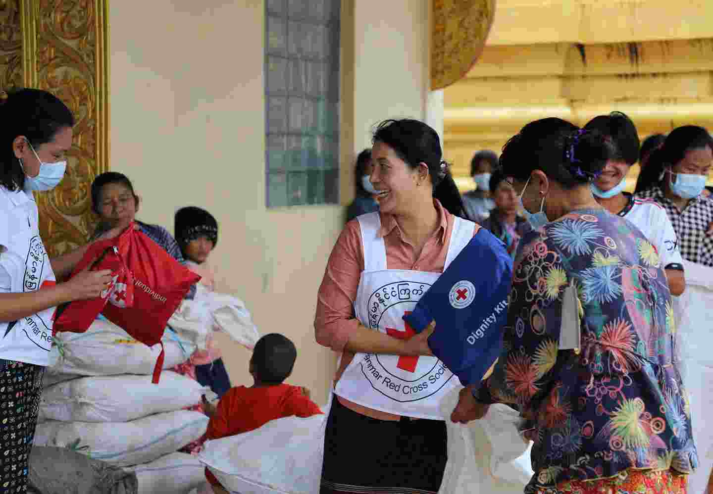 En frivillig inom Röda Korset delar ut hjälppaket.