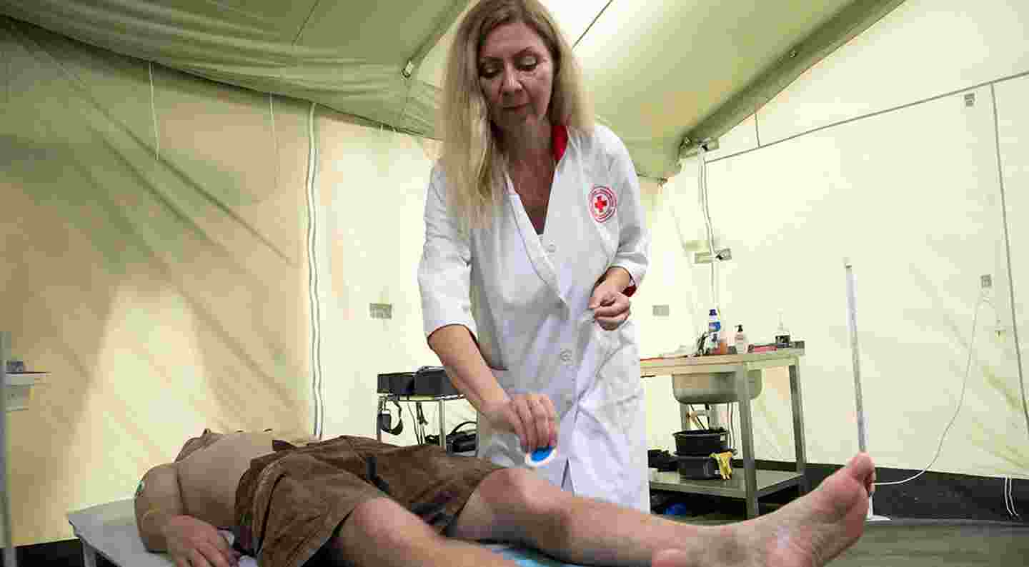 En läkare vårdar en patient på en hälsoklinik i ett tält.