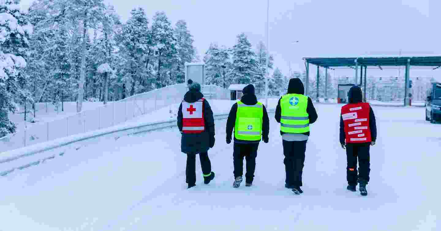 Två frivilliga från Röda Korset och två från Frivilliga räddningstjänsten går nära gränsområdet i vintervädret.