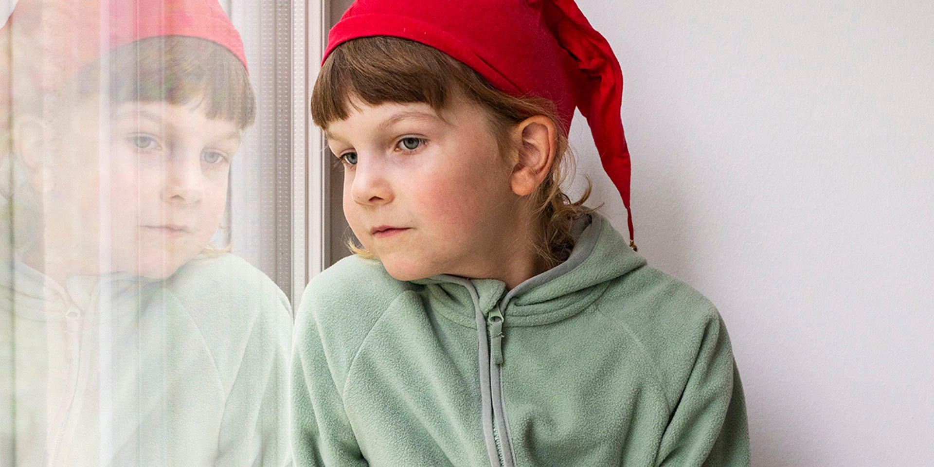 Ett barn tittar ut genom fönstret.