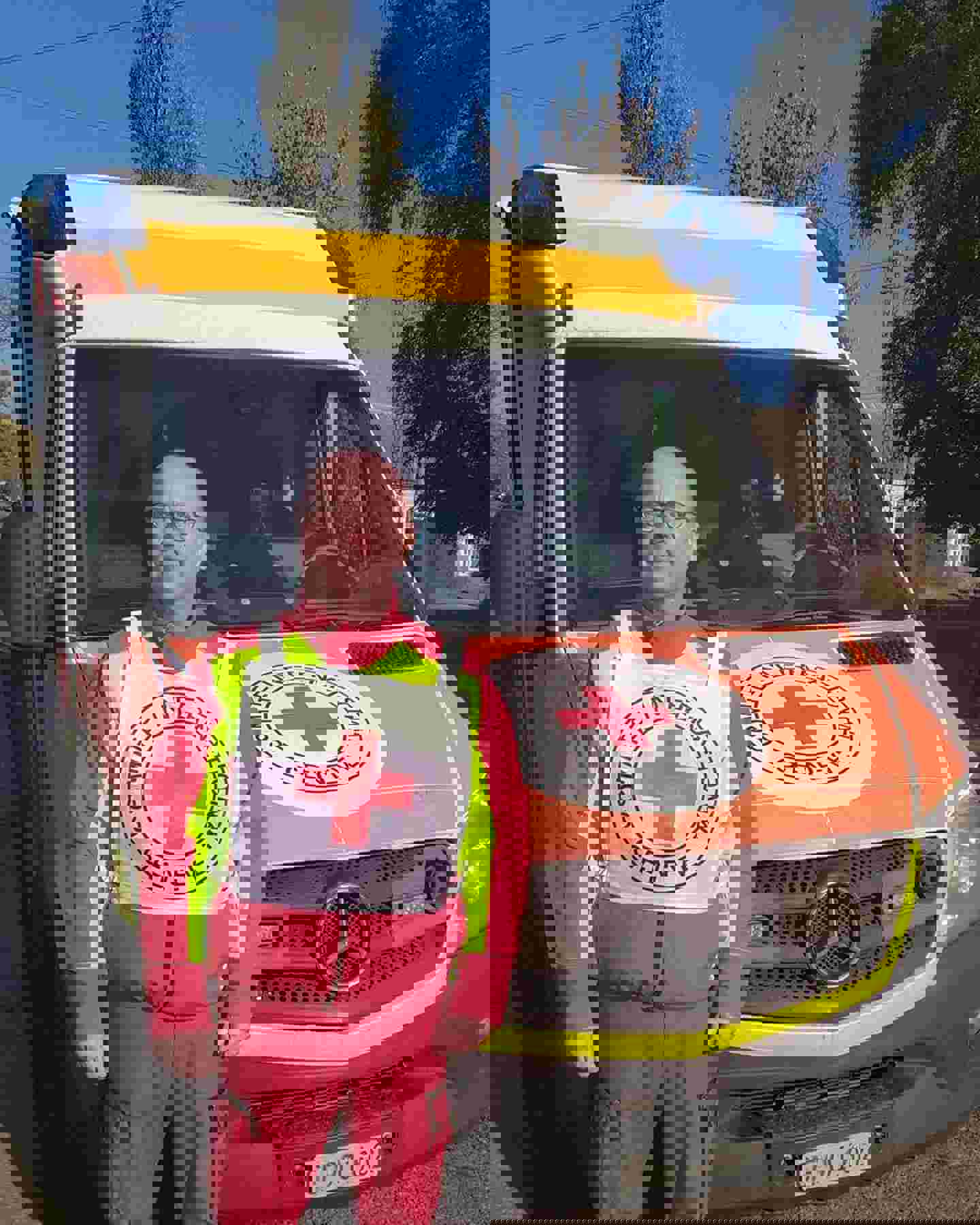 Primärvårdare Tuomo Hämäläinen ler bredvid Röda Korskommitténs ambulans