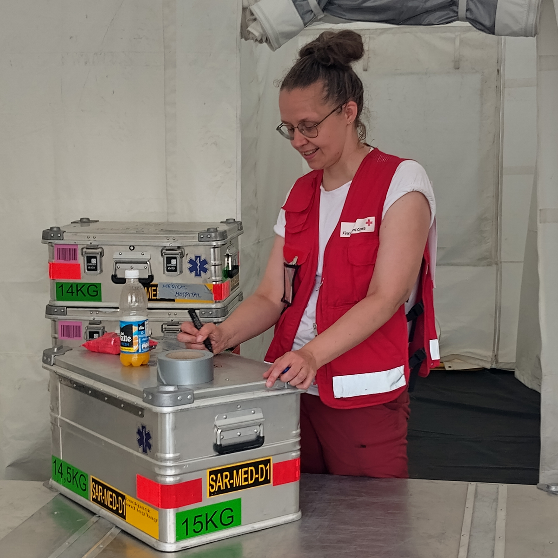 Biståndsarbetaren sorterar och packar medicinska förnödenheter.
