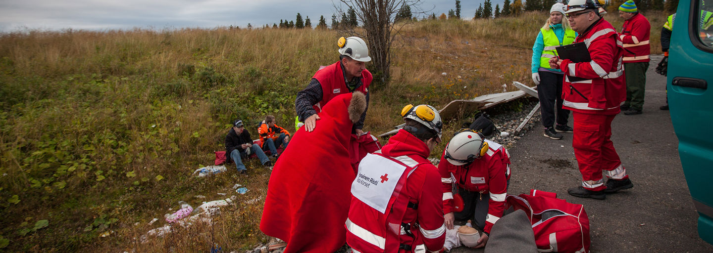 Röda Korsets utbildare lär barnen att vända en medvetslös person i stabilt sidoläge.
