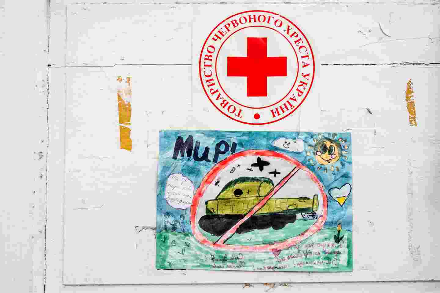 Ett barns teckning av en pansarvagn, med Röda Korsets logotyp ovanför.