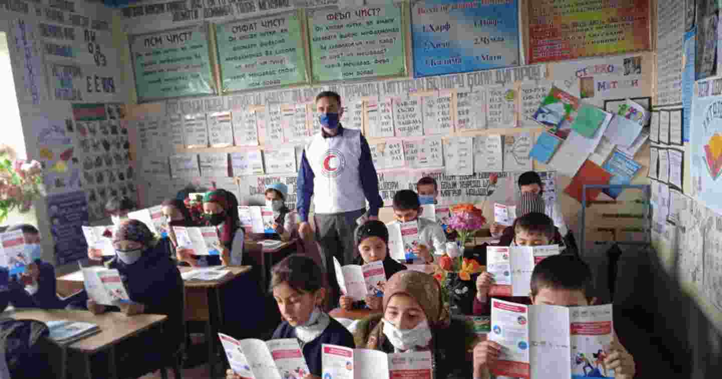 En grupp barn läser broschyrer i klassrummet.