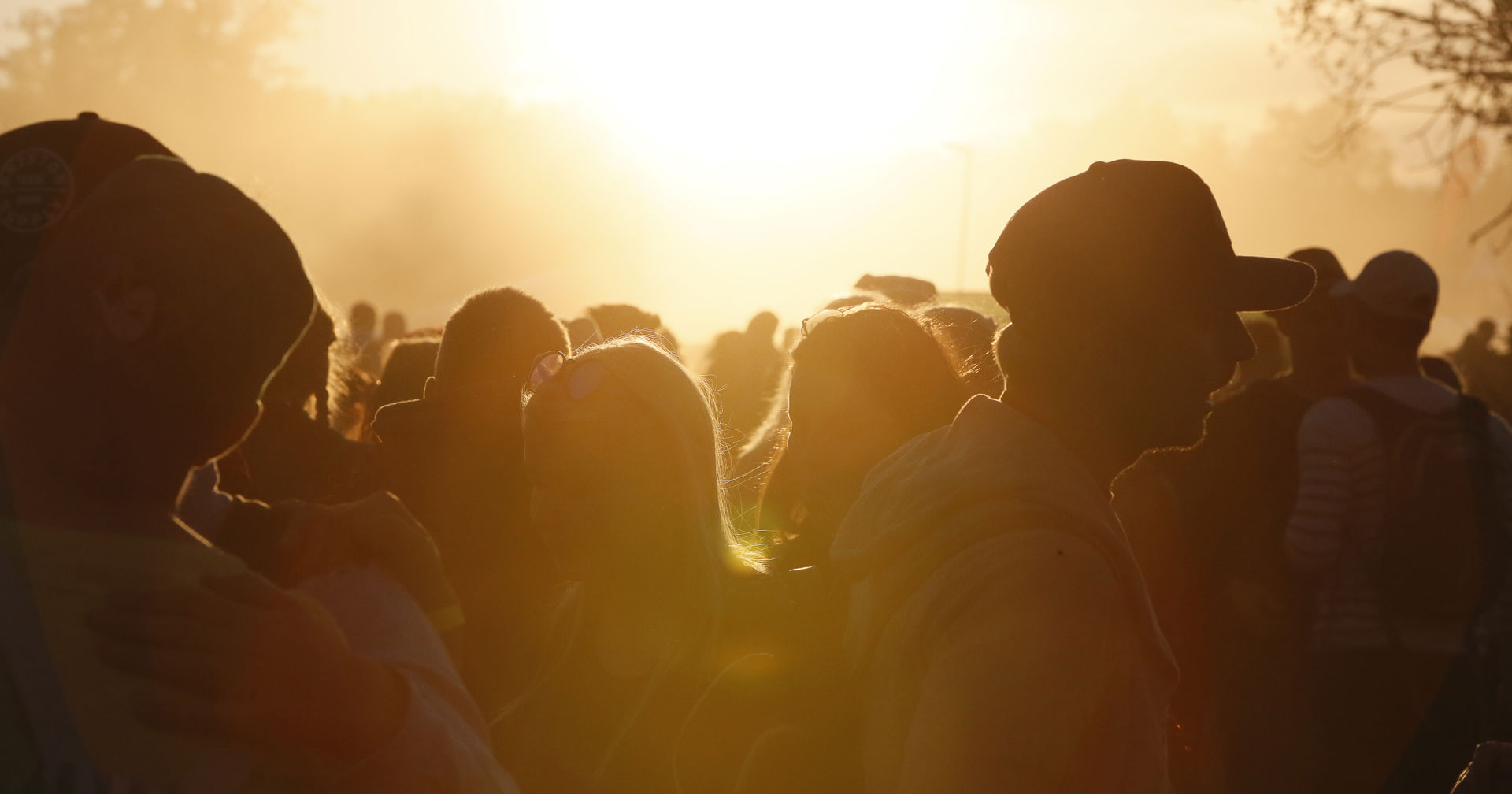 Silhuett av unga festare i festivalkvällens solnedgång.